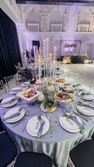 Elegant wedding reception hall with round tables and crystal chandeliers