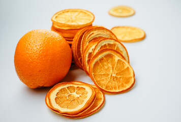 A vivid orange alongside its dried slices showcases the transformation from juicy freshness to...