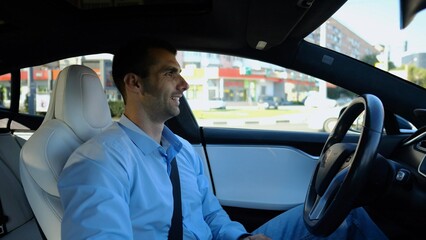 Male businessperson experience to ride an autonomous self driving electric car at urban road....