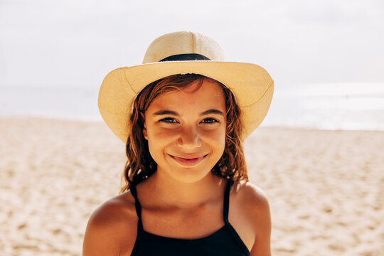 Portrait of smiling girl wearing hat at beach