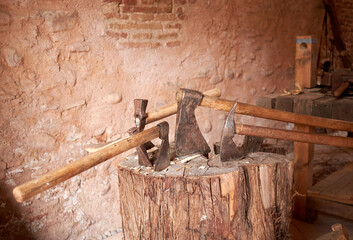 Hachas artesanas medievales clavadas en un tronco