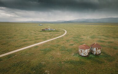 Dirt road and abandoned grain silos in the countryside in Carrizo National Monument, Santa Margarita, California, United States of America.