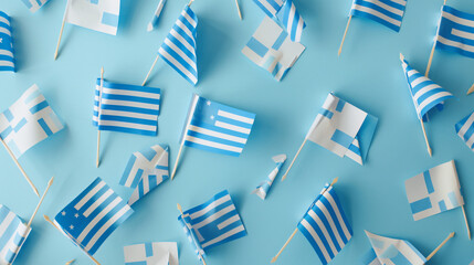 Many paper flags of Greece on light blue background