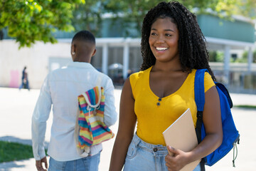 Beautiful black female student with backpack and male student in background