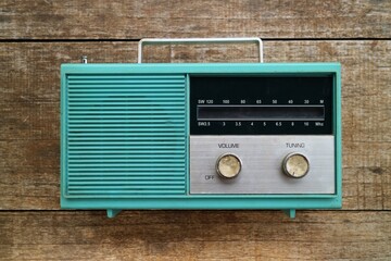 old green transistor radio circa 1960s with wooden background