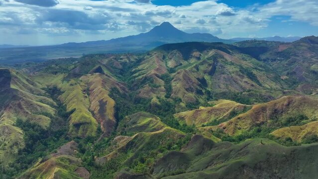 Aerial panorama view of Matutum Mountains with green landscape in South Cotabato in Philippines. Tropical scenery with Stratovolcano in Background. Wide shot.
