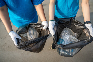 Group teamwork volunteer pick up the plastic bottle on the beach. People male and female Volunteer...