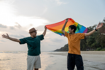 Young couple asian gay with pride movement LGBT holding rainbow flag raise up for freedom....