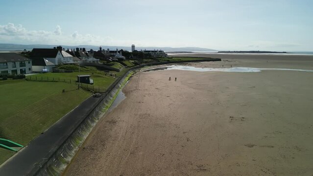 Hoylake Beachfront conservation area - aerial drone flyover towards Hilbre Island, Wirral, UK