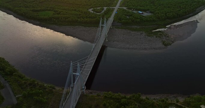 Aerial view backwards over the Sami Bridge and river, sunset in Utsjoki, Finland