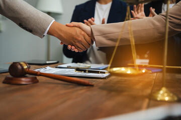 Lawyer shaking hands with client after discussing final contract agreement.
