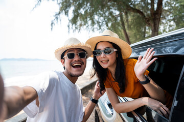 Young asian couple man and woman travel by car on a bright day to the sea sand beach with beautiful...