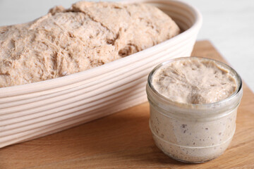 Fresh sourdough starter and dough on table, closeup