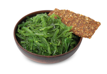 Tasty seaweed salad in bowl and crispbread isolated on white