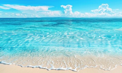 A close up of the clear sky and sea, with soft sand on the beach in front and blurred background