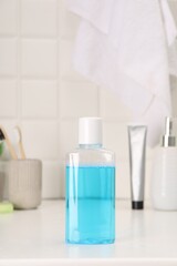 Bottle of mouthwash on white table in bathroom