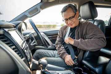 Senior asian men getting new car and putting on his seat belt before driving car. Safety drive concept. - Powered by Adobe