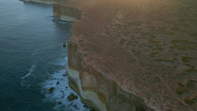 Backward aerial view of Nullarbor Cliffs during daytime in South Australia. One of the longest sea cliffs in the world.