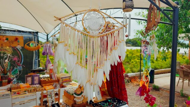Dream catcher with feathers hanging in an outdoor tent moving with the wind.
