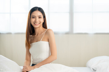 Young woman wake up before lying asleep enjoying healthy in the morning.  Beautiful asian woman sleeping well in comfortable cozy fresh bed on soft pillow white linen.