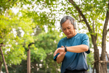 Mature man wearing sportswear using Smart Watch Showing Heart Rate Monitor. Old man with Technology for health and sport mode. Exercise and take statistics to develop your potential