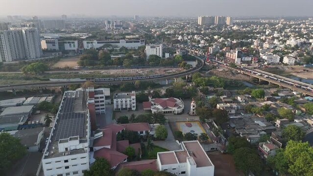 A picturesque drone footage capturing the beauty of Chennai's skyline, with clouds adding a touch of drama to the cityscape with two trains passing.