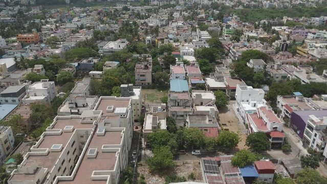 A cinematic drone shot capturing the essence of Chennai's urban life, from the bustling streets to the serene residential neighborhoods, all under a cloudy sky.