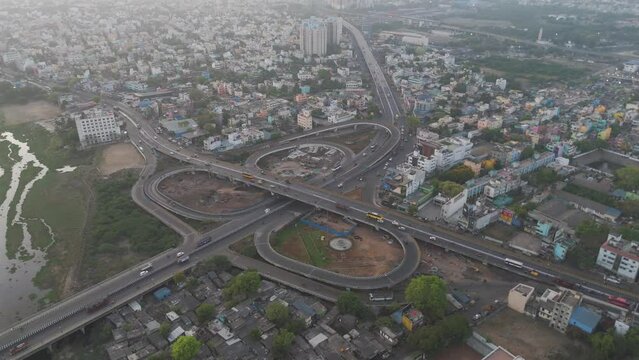 A cinematic drone shot of Chennai, highlighting the city's bustling activity and architectural grandeur under a cloudy sky.
