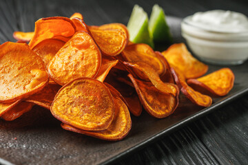 sweet potato chips on a dark wooden rustic background