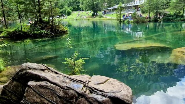 amazing Swiss mountain lakes - beautiful fairytale Blausee lake with clear trasparent waters. near Kandersteg village. Switzerland travel and scenery
