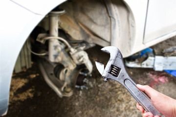 An adjustable spanner or adjustable wrench in the hand of an auto mechanic in the vehicle maintenance shop , Car maintenance service concept