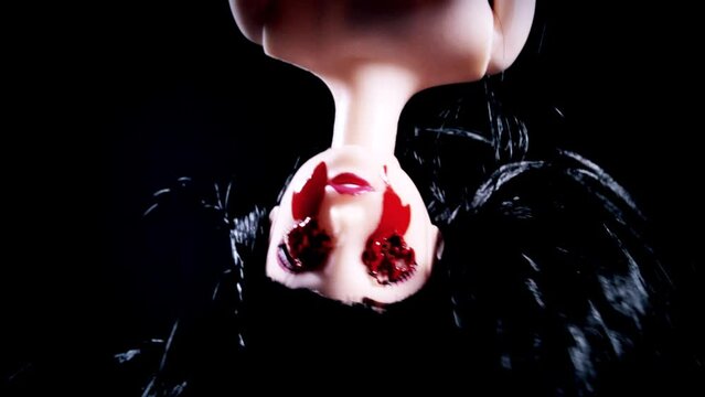An eerie, eyeless doll, with burnt and bleeding eyes, appears upside down. A classic horror Halloween theme, closeup shot.