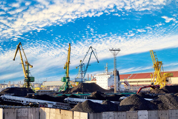 Coal harbour at ocean dry bulk terminal, coal stockpiles, portal cranes and mobile conveyors.