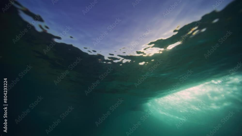 Poster light rays sparkle on sand under breaking wave crashing with vortex