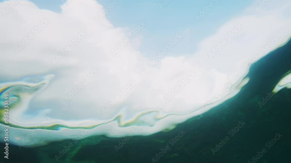 Poster mesmerizing liquid pattern distorted from behind wave as surfer rides in clear water