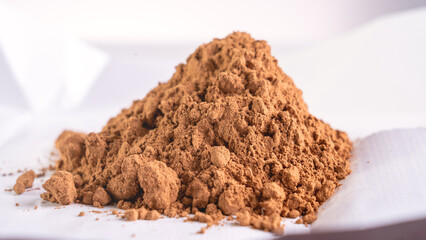 Cocoa powder close-up. Cocoa and a bar of dark chocolate on a white background. The concept of inflation and rising prices for raw materials for production.