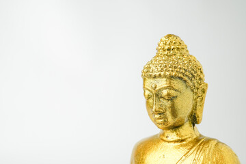 A golden statue of a Buddhist figure meditating facing the side isolated on white background....