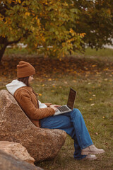 Woman typing on laptop during freelance work in park