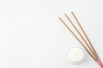 Isolated Empty white background decorated with white round candle and yellow colored incense....