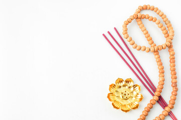 Isolated Empty white background decorated with colorful flowers, red colored incense and prayer beads. Concept for Vesak Day and Enlightenment Day. Empty blank copy text space