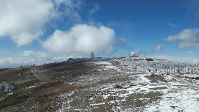 Vista a&eacute;rea de monta&ntilde;as nevadas y c&uacute;pulas de observatorio del calar alto.