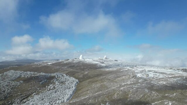Vista a&eacute;rea de monta&ntilde;as nevadas y c&uacute;pulas de observatorio del calar alto.