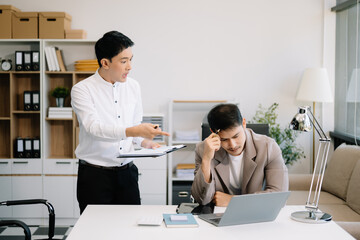 Furious two Asian businesspeople arguing strongly after making a mistake at work