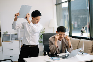 Furious two Asian businesspeople arguing strongly after making a mistake at work