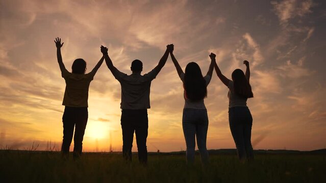 friendly team of people silhouette a raise their hands up. business team teamwork concept. success team people silhouette raise their hands up. friendly family hold hands raise up success lifestyle