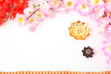 Isolated Empty white background decorated with colorful flowers, red colored incense and prayer beads. Concept for Vesak Day and Enlightenment Day. Empty blank copy text space