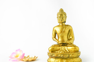 A golden statue of a Buddhist figure meditating decorate with colorful flowers facing the front isolated on white background. Concept for Vesak Day and Enlightenment Day