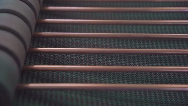 Factory production of heat exchanger. Copper and steel pipes coming out on line from Heavy pipe reducer machinery in workshop. Lots of pipes to produce. Heating element. Close up.