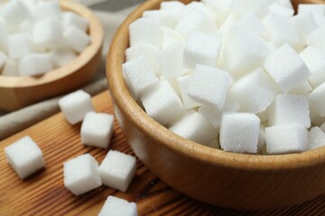 White sugar cubes on wooden table, closeup