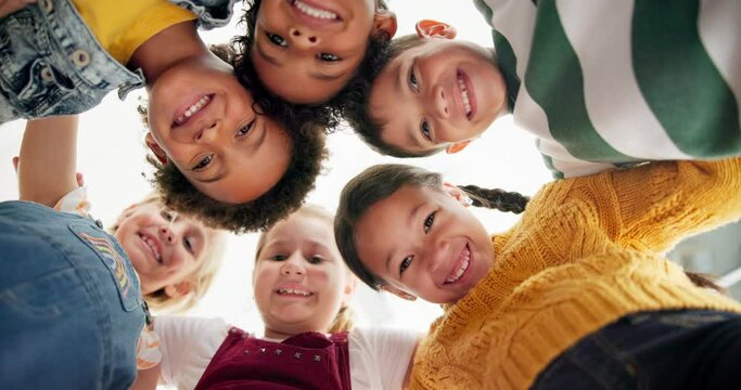Huddle, support and happy children in school for education, community or development. Low angle, diversity and group of friends with smile in playground for solidarity, teamwork or playing together - Powered by Adobe